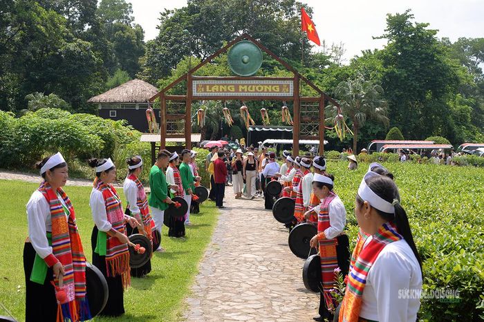 Đồng bào Mường trong trang phục truyền thống đánh chiêng đón đoàn đại biểu quốc tế. Ảnh: Tuấn Anh