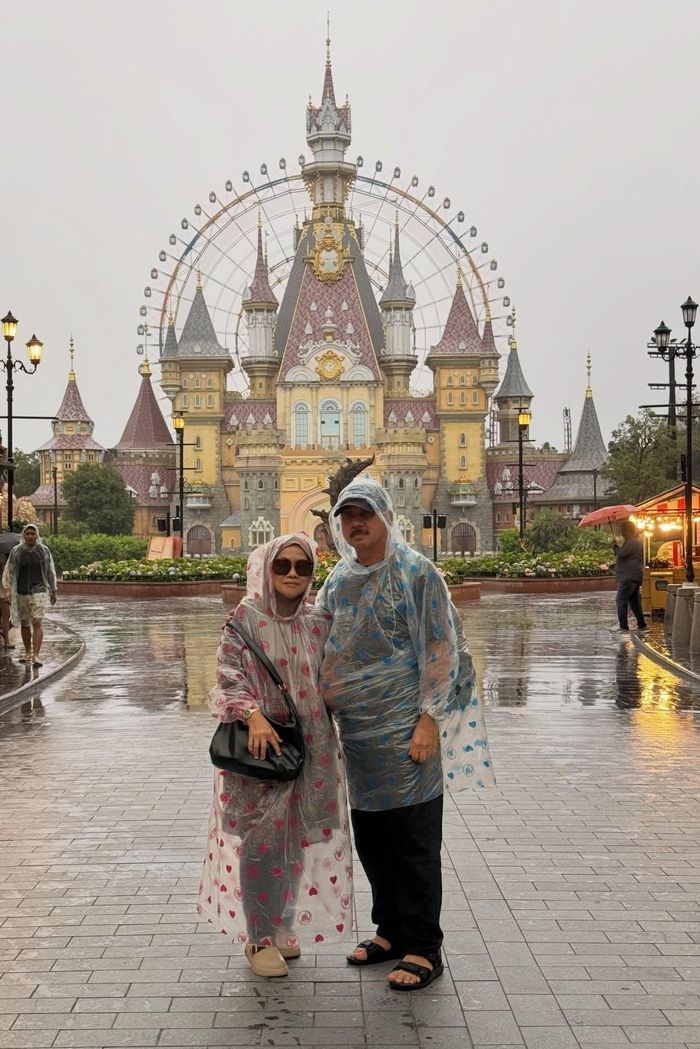 Nazri Hamid (du khách Malaysia) cùng gia đình mặc áo mưa chụp ảnh tại những điểm du lịch ở Phú Quốc. Ảnh: NVCC.