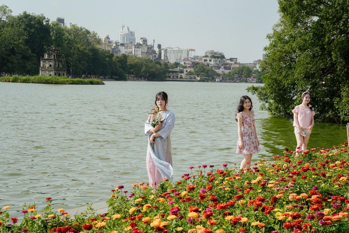 Vũ Lưu Bảo Ngọc (sinh năm 2007, ngụ phường Đông Ngạc, bên trái) cho biết thấy nhiều hình ảnh Hà Nội vào thu trên mạng xã hội nên rủ bạn bè chuẩn bị từ make-up, làm tóc đến trang phục để check-in Hồ Gươm.