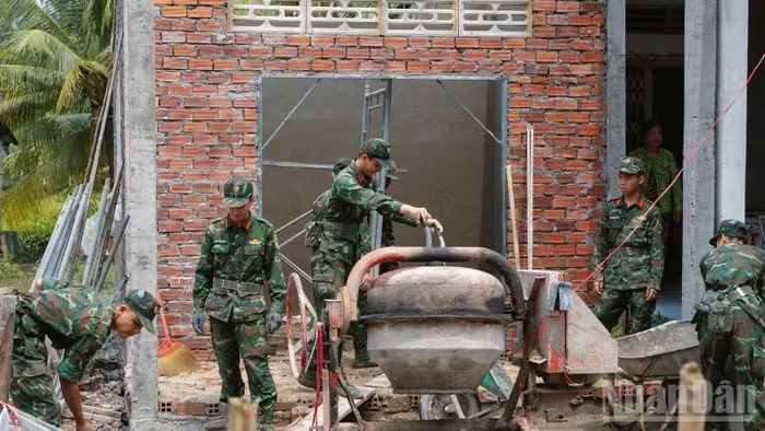 Lực lượng tham gia hỗ trợ xóa nhà tạm, nhà dột nát cho con người có công. (Ảnh: VĂN ÚT)