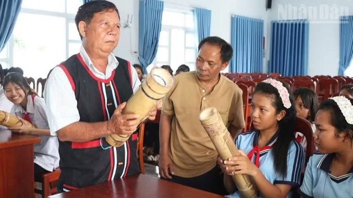 Nghệ nhân Tà Thía Banh, xã Phước Hà cùng học sinh hòa tấu đàn Chapi trong buổi truyền dạy. (Ảnh: NGUYỄN TRUNG)