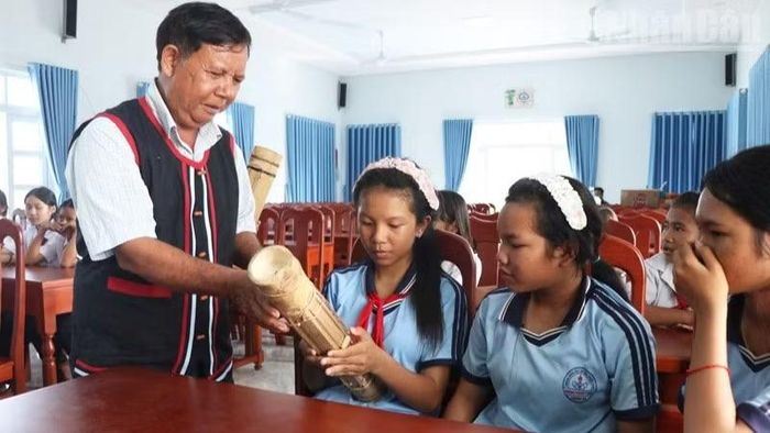 Nghệ nhân Tà Thía Banh, xã Phước Hà, hướng dẫn học sinh từng động tác cầm đàn, tạo nhịp và lắng nghe âm thanh đàn Chapi. (Ảnh: NGUYỄN TRUNG)