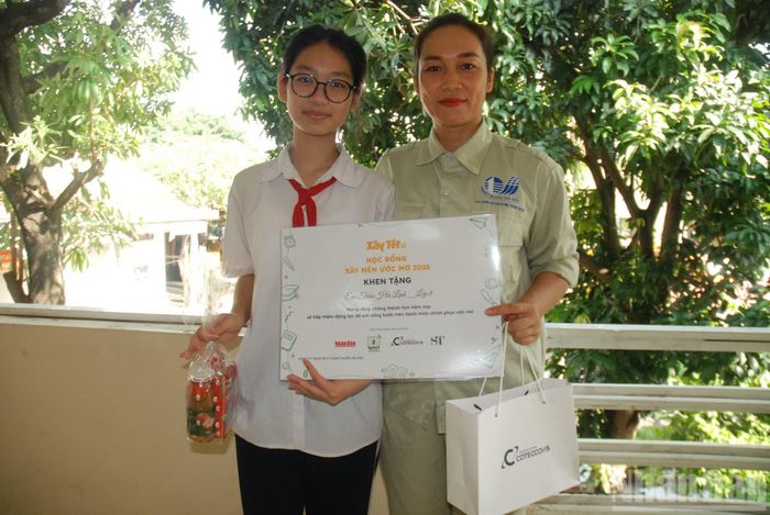 Chị Đặng Thị Thu Hà và con gái Trần Hà Linh chia sẻ niềm vui khi tham dự chương trình học bổng "Xây nền ước mơ" do Báo Nhân Dân cùng các đơn vị tổ chức. (Ảnh: VĂN TOẢN)