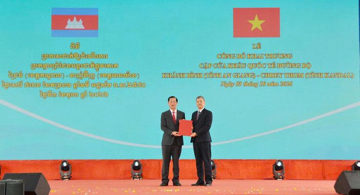 Ông Nguyễn Hoàng Hải (phải), Phó Chủ nhiệm Ủy ban Biên giới quốc gia (Bộ Ngoại giao) trao Nghị quyết của Chính phủ về việc phê duyệt nâng cấp Cửa khẩu chính Khánh Bình lên Cửa khẩu quốc tế đường bộ Khánh Bình cho Phó Chủ tịch UBND tỉnh An Giang Lê Văn Phước