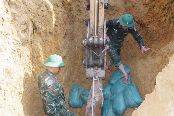 Di chuyển quả bom xuống hố sâu để chuẩn bị hủy nổ. Ảnh: TRỌNG SƠN 