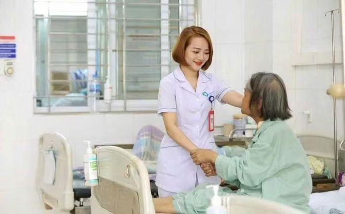 Y bác sĩ ân cần thăm hỏi, chăm sóc sức khỏe cho người bệnh tại bệnh viện, thể hiện tinh thần y đức và sự tận tâm vì người bệnh. Ảnh: Sở Y tế QN.