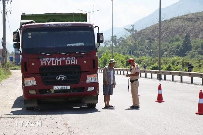 Lực lượng Cảnh sát giao thông thành phố Huế tăng cường kiểm tra phương tiện chở hàng quá khổ, quá tải trên Quốc lộ 1A. (Ảnh: Mai Trang/TTXVN)