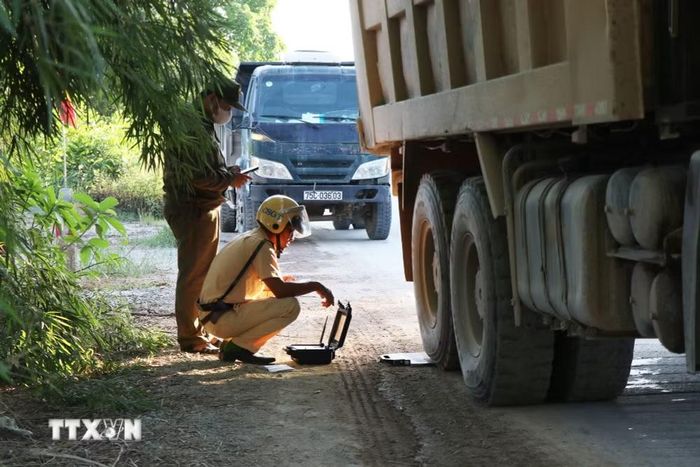 Lực lượng chức năng kiểm tra trọng tải phương tiện. (Ảnh: Mai Trang/TTXVN)