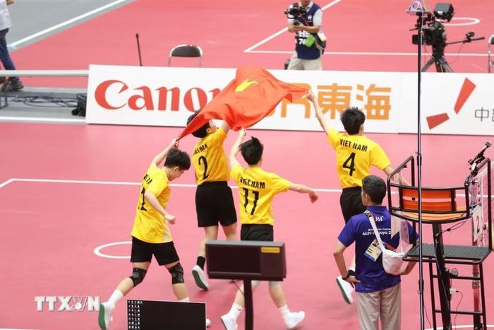 Các tuyển thủ cầu mây nữ Việt Nam ăn mừng chiến thắng với lá cờ Tổ quốc. (Ảnh: TTXVN phát)