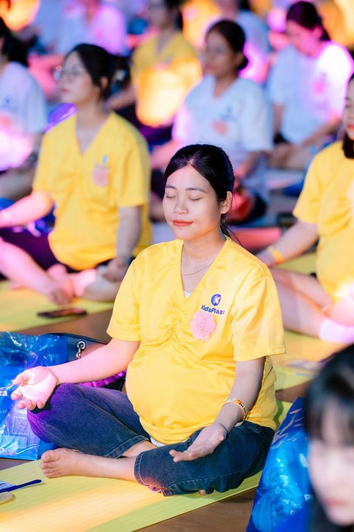 Các mẹ bầu trình diễn với các động tác yoga. (Ảnh: PV/Vietnam+)