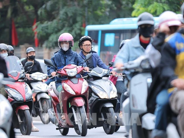 Nhiều người dân Hà Nội đã mặc thêm đồ ấm khi nhiệt độ giảm. Ảnh tư liệu: Hoàng Hiếu - TTXVN