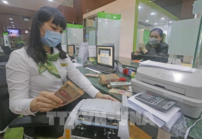 Khách hàng giao dịch tại hội sở chính Vietcombank, 198 Trần Quang Khải, Hà Nội. Ảnh: Trần Việt - TTXVN