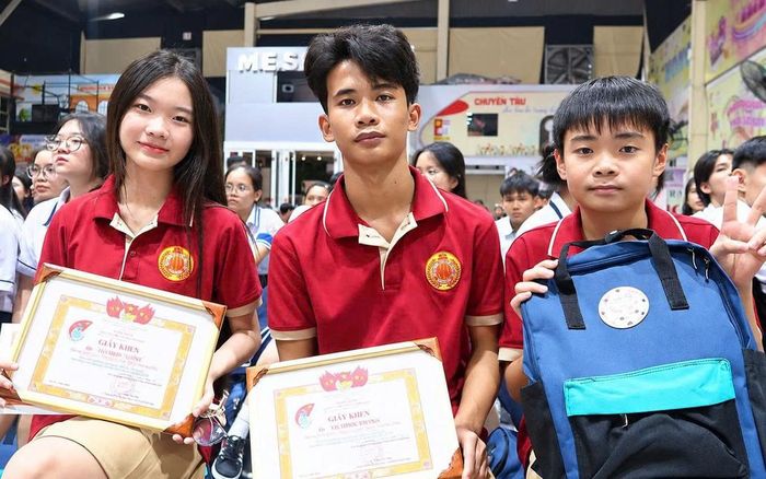Em Châu Sóc Khang (giữa) - học sinh lớp 12A2, Trường THCS- THPT Nam Việt - cùng các bạn nhận phần thưởng tại chương trình