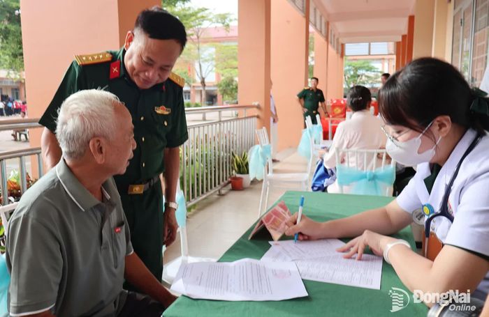 Đại tá Nguyễn Như Trúc, Phó Chủ nhiệm Chính trị Quân khu 7 động viên người có công đến khám bệnh. Ảnh: Nguyệt Hà