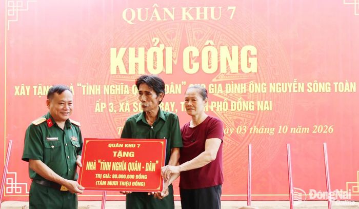 Đại tá Nguyễn Như Trúc, Phó Chủ nhiệm Chính trị Quân khu 7 trao tặng bảng tượng trưng khởi công xây dựng nhà tình nghĩa quân dân. Ảnh: Nguyệt Hà