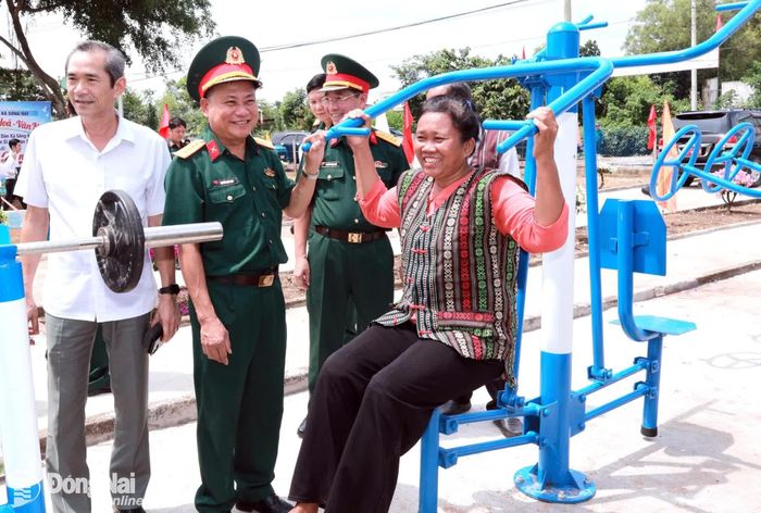 Thủ trưởng Quân khu 7 và đại biểu tham quan, hướng dẫn người dân tập luyện thể thao tại công trình thể dục thể thao ngoài trời. Ảnh: Nguyệt Hà