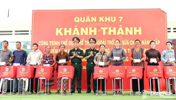 Đại tá Nguyễn Thanh Phong, Thành ủy viên, Chính ủy Bộ Chỉ huy Quân sự thành phố và Đại tá Vũ Đức Hiến, Sư đoàn trưởng Sư đoàn 302, Quân khu 7 tặng quà cho gia đình khó khăn là đồng bào dân tộc thiểu số trong buổi lễ. Ảnh: Nguyệt Hà