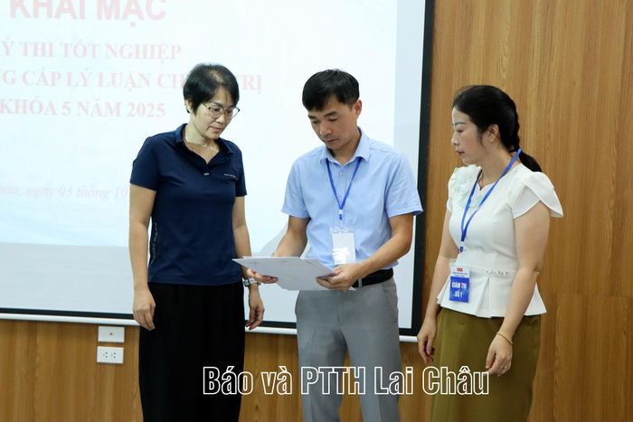 Viên chức Phòng Quản lý đào tạo và Nghiên cứu khoa học cùng học viên kiểm tra tình trạng đề thi.