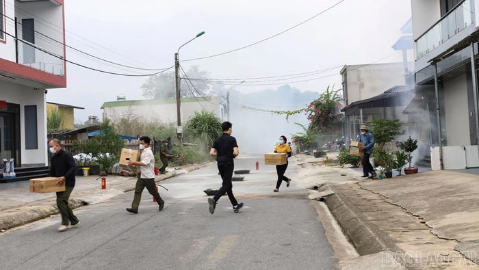 Các thành viên Tổ liên gia hỗ trợ hộ gia đình di chuyển tài sản ra khỏi khu vực nguy hiểm.