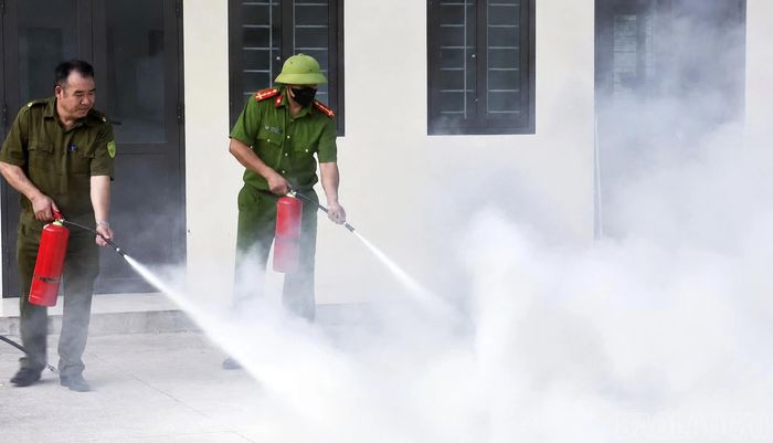  Lực lượng tham gia diễn tập sử dụng bình chữa cháy phun bột dập lửa. 