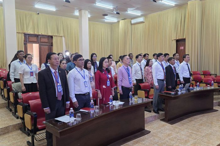 Các đại biểu tham dự Lễ kết nạp đảng viên mới thực hiện nghi thức chào cờ