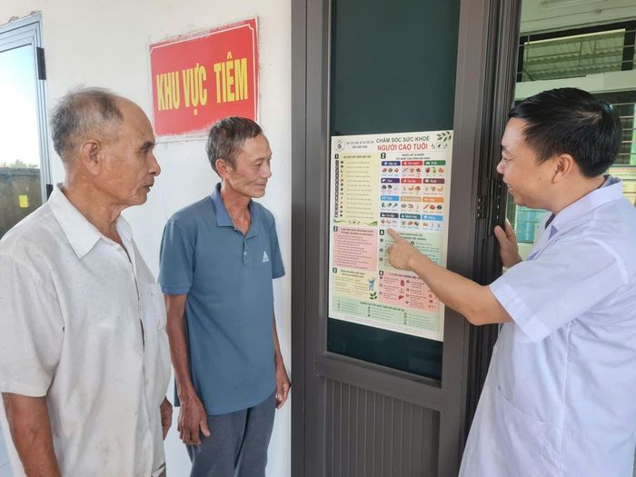 Nhân viên Trạm Y tế xã Giao Hoà cung cấp kiến thức chăm sóc sức khoẻ cho người cao tuổi.