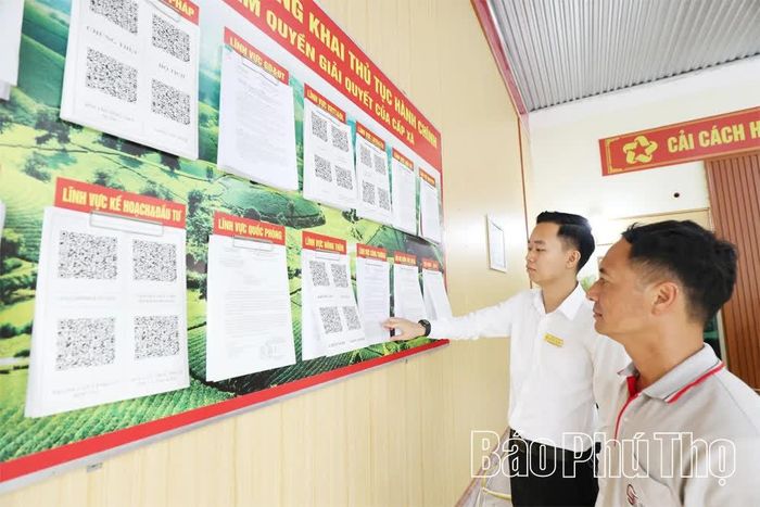 Người dân xã Long Cốc được cán bộ hướng dẫn cách tra cứu, tìm hiểu thông tin về thủ tục hành chính thông qua mã QR, thuận tiện và nhanh chóng.