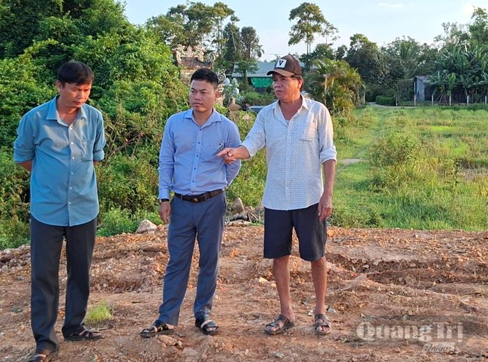 Ông Nguyễn Lưu (ngoài cùng bên phải) trao đổi với lãnh đạo Phòng Kinh tế xã Ái Tử và Trưởng thôn Bắc Long tại khu đất mà ông đã đổ đất - Ảnh: N.V