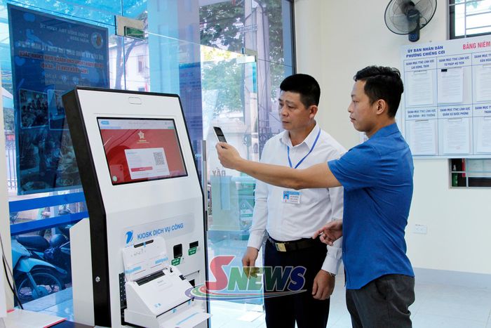 Cán bộ Trung tâm Phục vụ hành chính công phường Chiềng Cơi hướng dẫn nhân dân thực hiện hồ sơ trực tuyến.