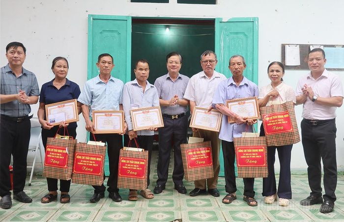 Đồng chí Trưởng ban Tổ chức Tỉnh ủy và lãnh đạo xã Đồng Tâm tặng quà và khen thưởng các hộ dân hiên đất làm cầu tại thôn Đoàn Kết.