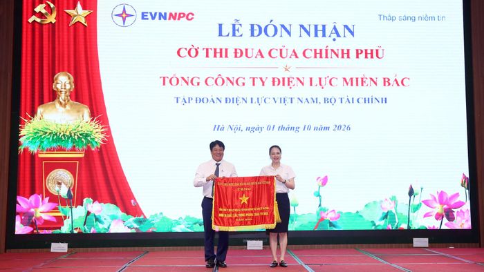 Thừa ủy quyền của Thủ tướng Chính phủ, ông Nguyễn Anh Tuấn, Phó Bí thư Đảng ủy, Thành viên HĐTV, Tổng Giám đốc EVN trao Cờ Thi đua của Chính phủ cho bà Đỗ Nguyệt Ánh, Bí thư Đảng ủy, Chủ tịch HĐTV EVNNPC. Ảnh NPC