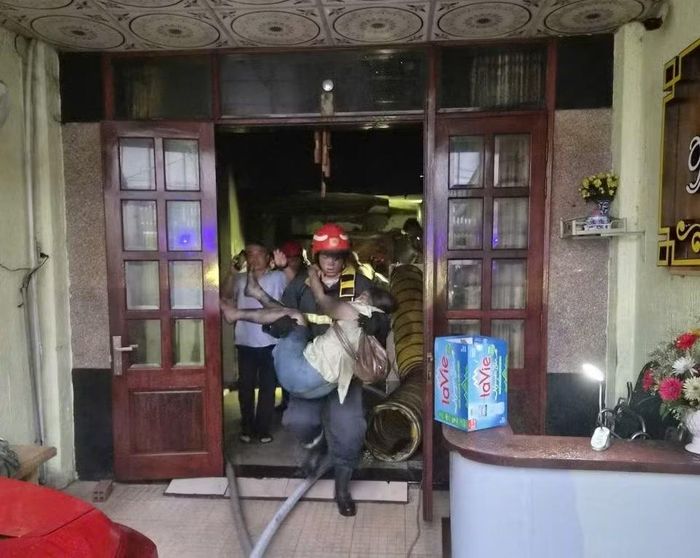 Nạn nhân bị mắc kẹt trong đám cháy được cán bộ chiến sĩ khẩn trương hỗ trợ, giúp thoát ra ngoài an toàn.