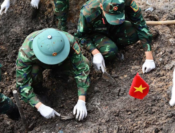 Các chiến sĩ Đội K74 tỉ mỉ tách từng lớp đất lẫn vào hài cốt các liệt sĩ.