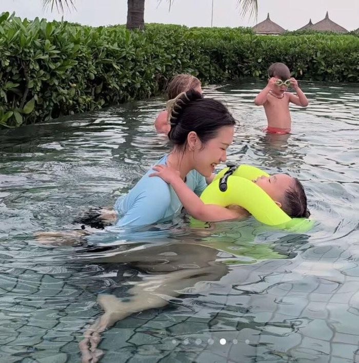 Bà mẹ dành thời gian dạy con trai tập bơi.