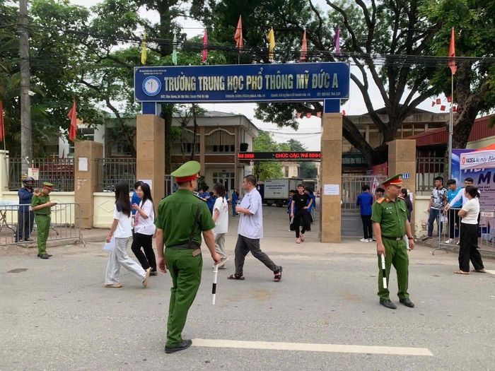 Lực lượng Công an xã Mỹ Đức trực phân luồng giao thông, bảo đảm an ninh trật tự tại điểm thi Trường THPT Mỹ Đức A tại kỳ thi tốt nghiệp THPT năm 2026. Ảnh: Biên Phạm