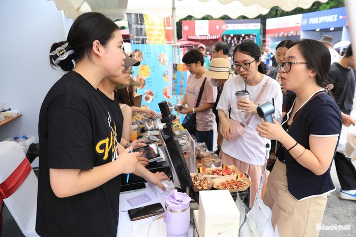 Du khách chăm chú tìm hiểu, lựa chọn các món ăn tại một gian hàng ẩm thực quốc tế.