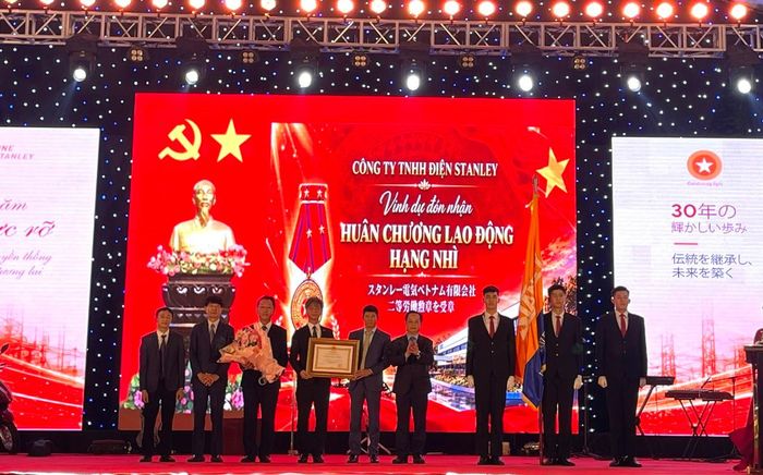 Thừa ủy quyền của Chủ tịch nước, Phó Chủ tịch Thường trực HĐND thành phố Hà Nội Trần Thế Cương trao Huân chương Lao động hạng Nhì cho Công ty TNHH Điện Stanley Việt Nam. Ảnh: PV