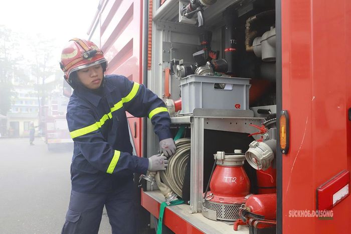 Chuẩn bị vòi chữa cháy từ khoang thiết bị chuyên dụng. Ảnh: Tuấn Anh