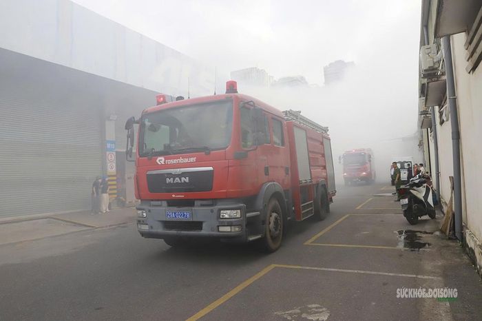 Xe chữa cháy triển khai trong màn khói dày đặc tại khu vực kho bãi. Ảnh: Tuấn Anh