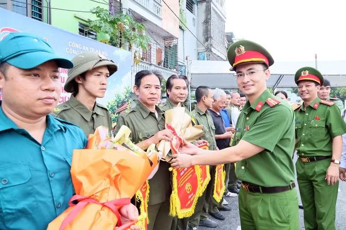 Nụ cười lấm lem khói bụi của các đội viên dân phòng khi nhận cờ lưu niệm sau lượt trận "thử lửa" đầy khốc liệt.