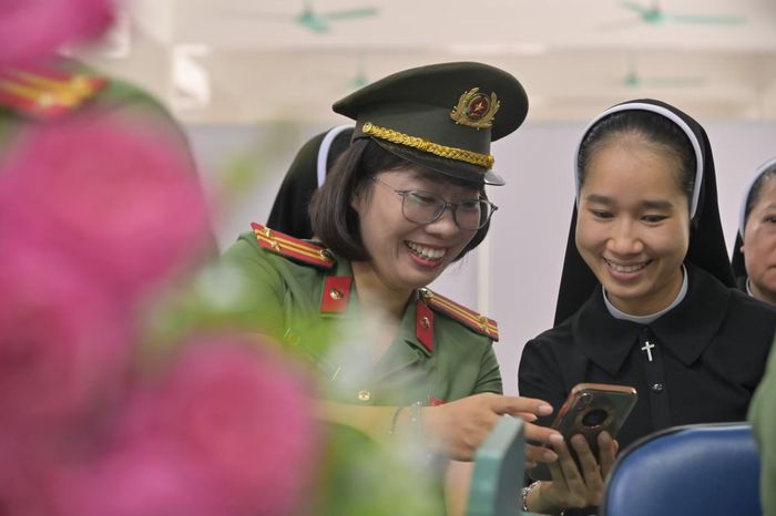 Nụ cười thân thiện của nữ cán bộ Công an phường Tùng Thiện (Hà Nội) khi hướng dẫn người dân sử dụng các tiện ích số, xóa nhòa khoảng cách hành chính khô cứng.