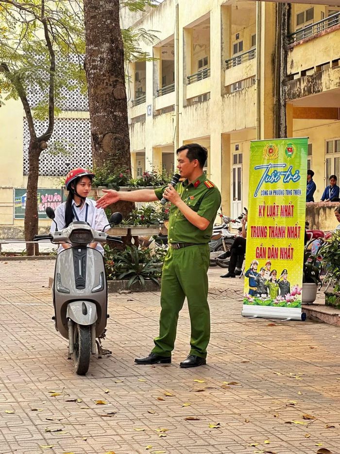 Cán bộ Công an phường Tùng Thiện trực hướng dẫn học sinh tham gia giao thông an toàn, cụ thể hóa thông điệp pháp luật vào đời sống.