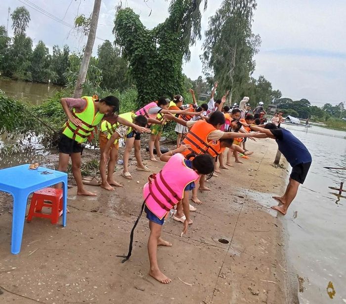 Giáo viên hướng dẫn các em khởi động trước khi bơi