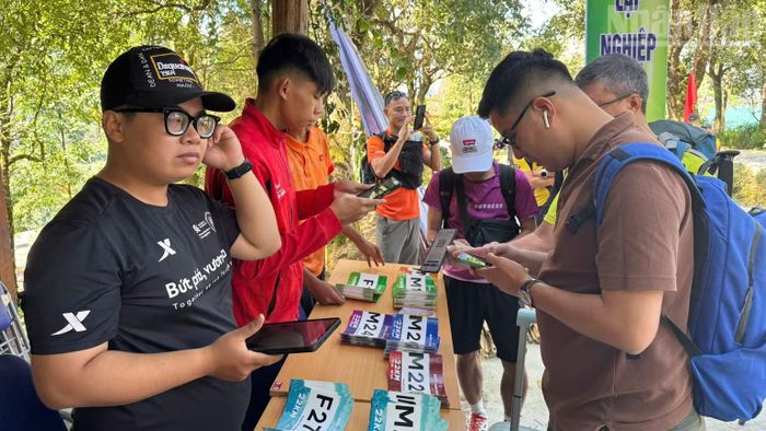 Du khách làm thủ tục tham gia giải leo núi chinh phục con đường đá cổ Pa Vi sau sự kiện đêm nhạc Y-Fest.