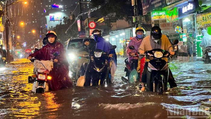 Mưa lớn khiến nhiều tuyến đường ngập nước, giao thông đi lại khó khăn trên đường Lê Văn Lương, xã Nhà Bè. (Ảnh: THẾ ANH)