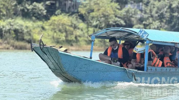 Khách du lịch trải nghiệm dịch vụ tàu vào hang động Phong Nha-Kẻ Bàng, Quảng Trị. (Ảnh: HNV)