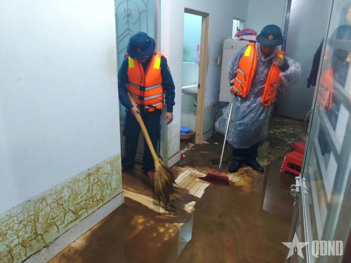 Cán bộ, chiến sĩ Ban CHQS phường B’Lao hỗ trợ người dân khắc phục hậu quả mưa lũ.