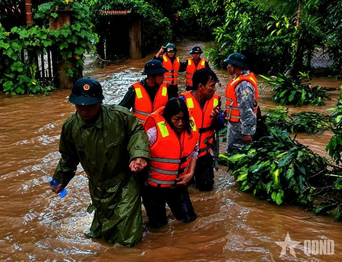 Cán bộ, chiến sĩ Ban CHQS phường B’Lao (tỉnh Lâm Đồng) đưa người dân đến nơi an toàn.