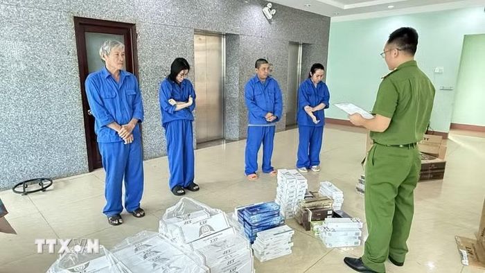 Các đối tượng buôn bán, tàng trữ 876 cây thuốc lá nhập lậu. Ảnh: TTXVN