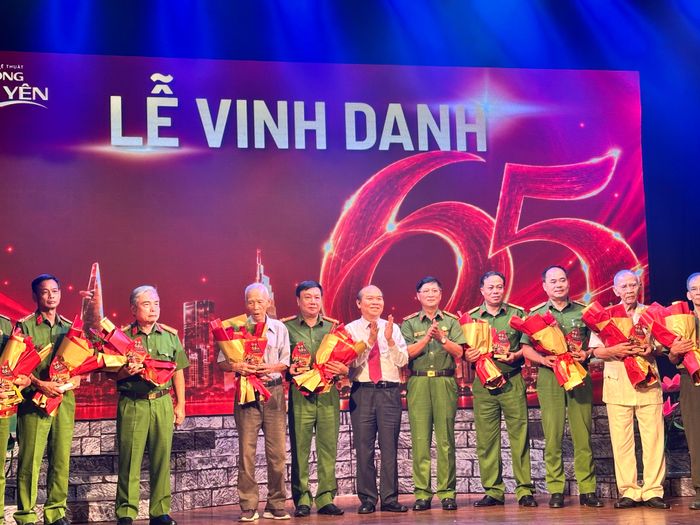 Phó Chủ tịch UBND TPHCM Trần Văn Bảy tặng hoa và kỷ niệm chương vinh danh lãnh đạo, cán bộ, chiến sĩ tiêu biểu qua các thời kỳ của lực lượng Cảnh sát PCCC và CNCH. Ảnh: THANH HIỆP